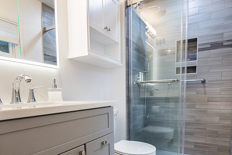 Modern Bathroom With Gray Cabinet White Countertop Backlit Mirror Gray Tiled Shower Glass Door Remodeled By Aladdin Carpet Gaithersburg Md